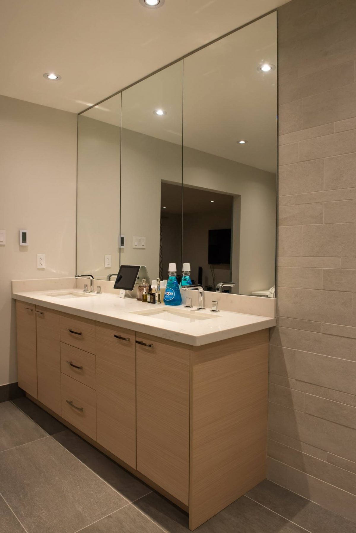 Frameless Mirror Placed on top of Stone Backsplash