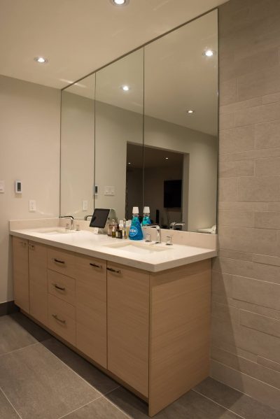 Frameless Mirror Placed on top of Stone Backsplash